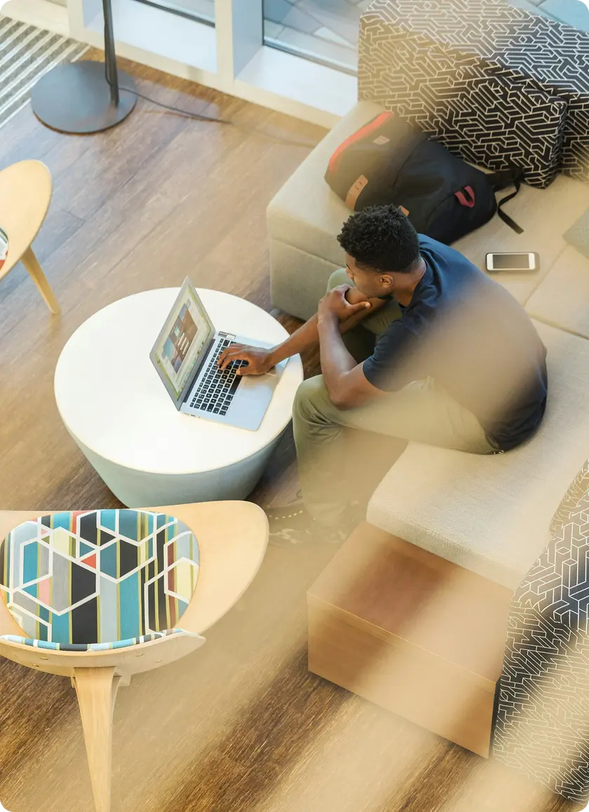 A learner working on a laptop in a modern lounge
